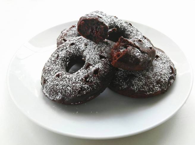 baked chocolate raspberry jam filled donuts with powdered sugar